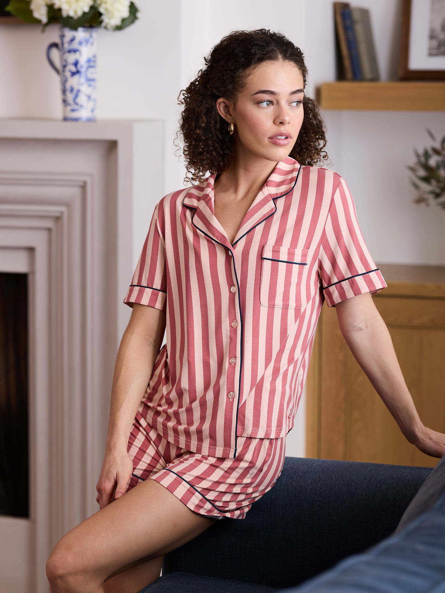 Woman in living room wearing blush stripe short sleeve pajama set