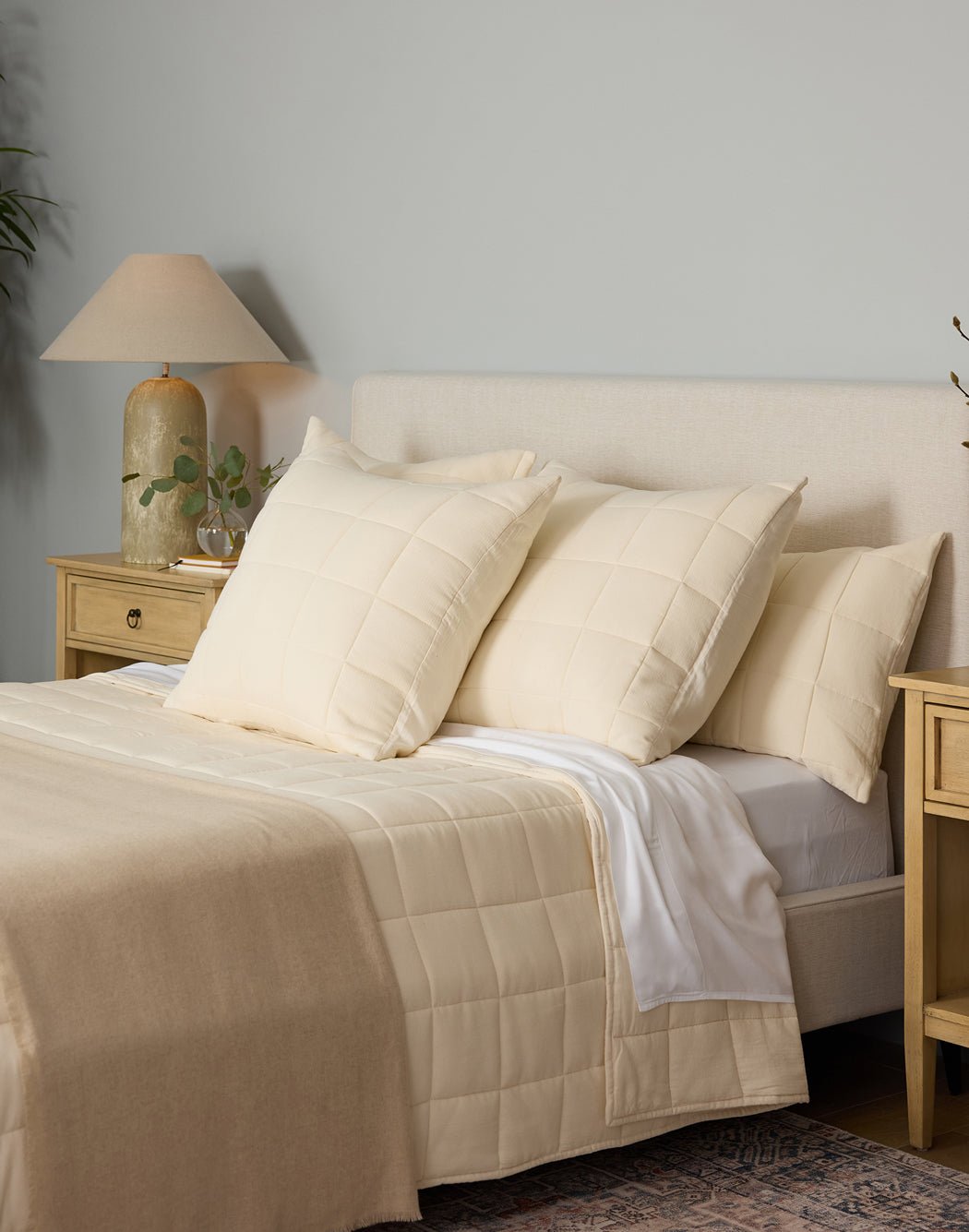Buttermilk Aire Bamboo Box Quilt Euro Sham. The sham is resting on a bed in a bedroom