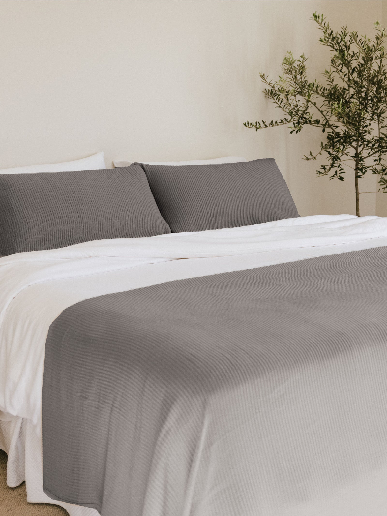 Charcoal coverlet and shams on a bed