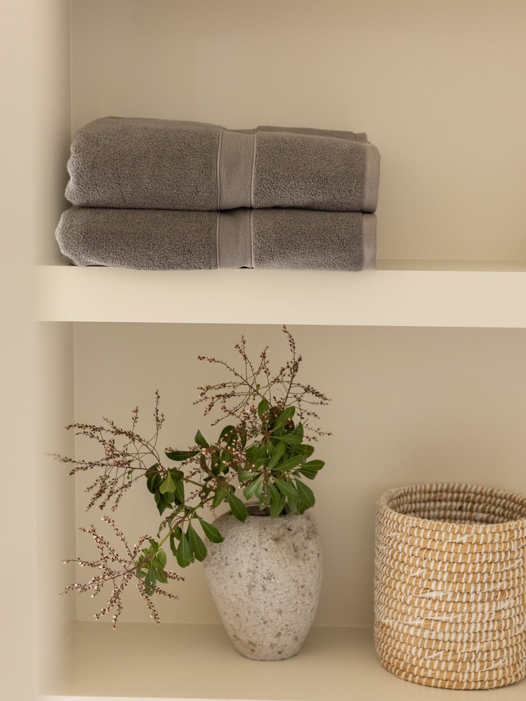 Charcoal luxe bath towels folded on shelf 