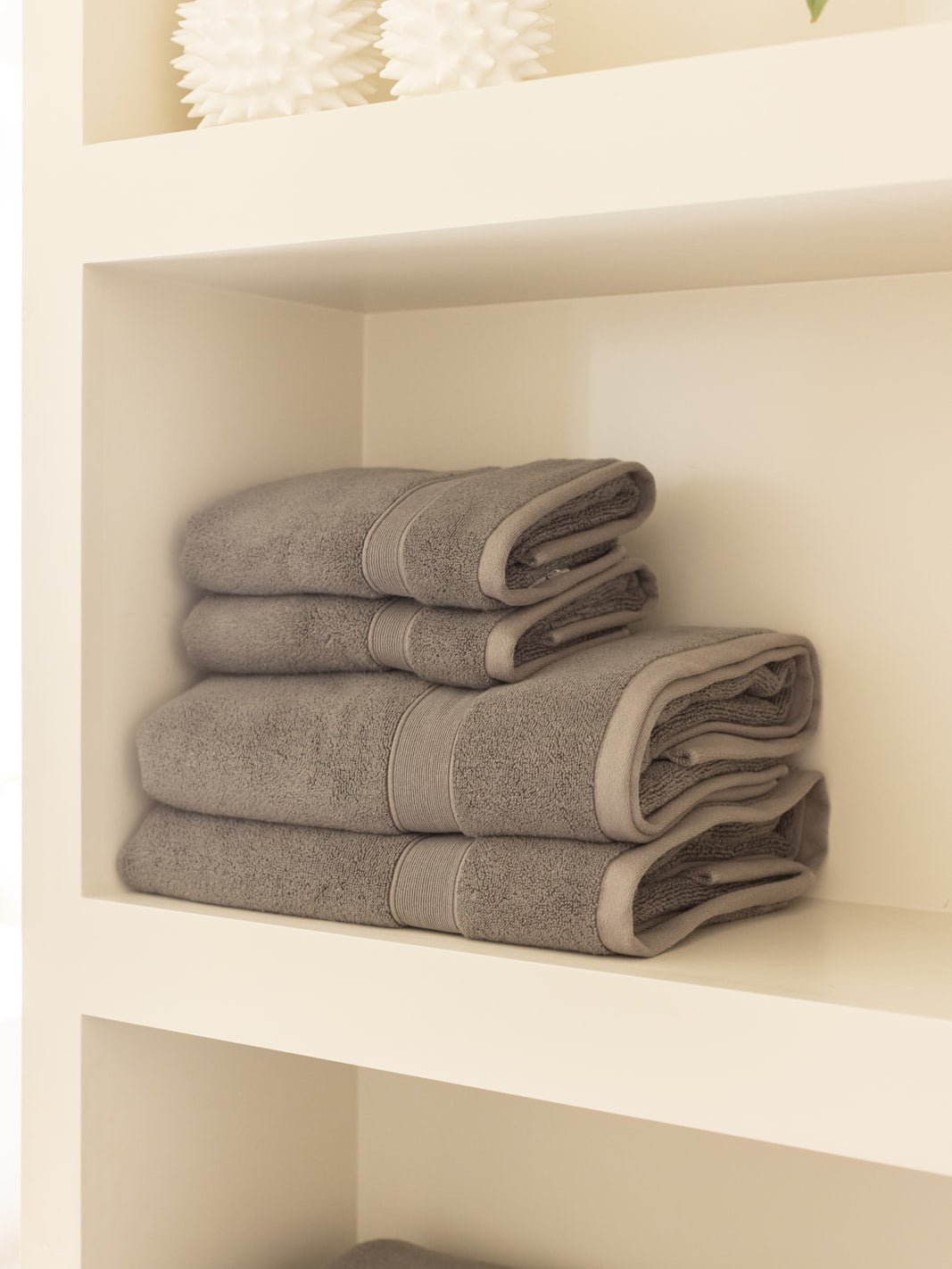 Charcoal luxe bath towels and hand towels folded on shelf 