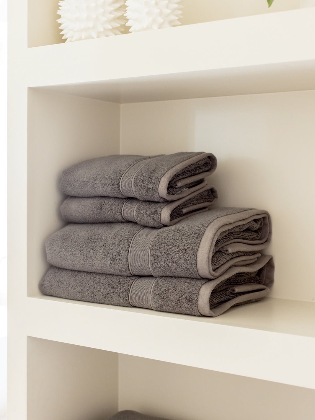 Charcoal hand and bath towels folded on shelf 