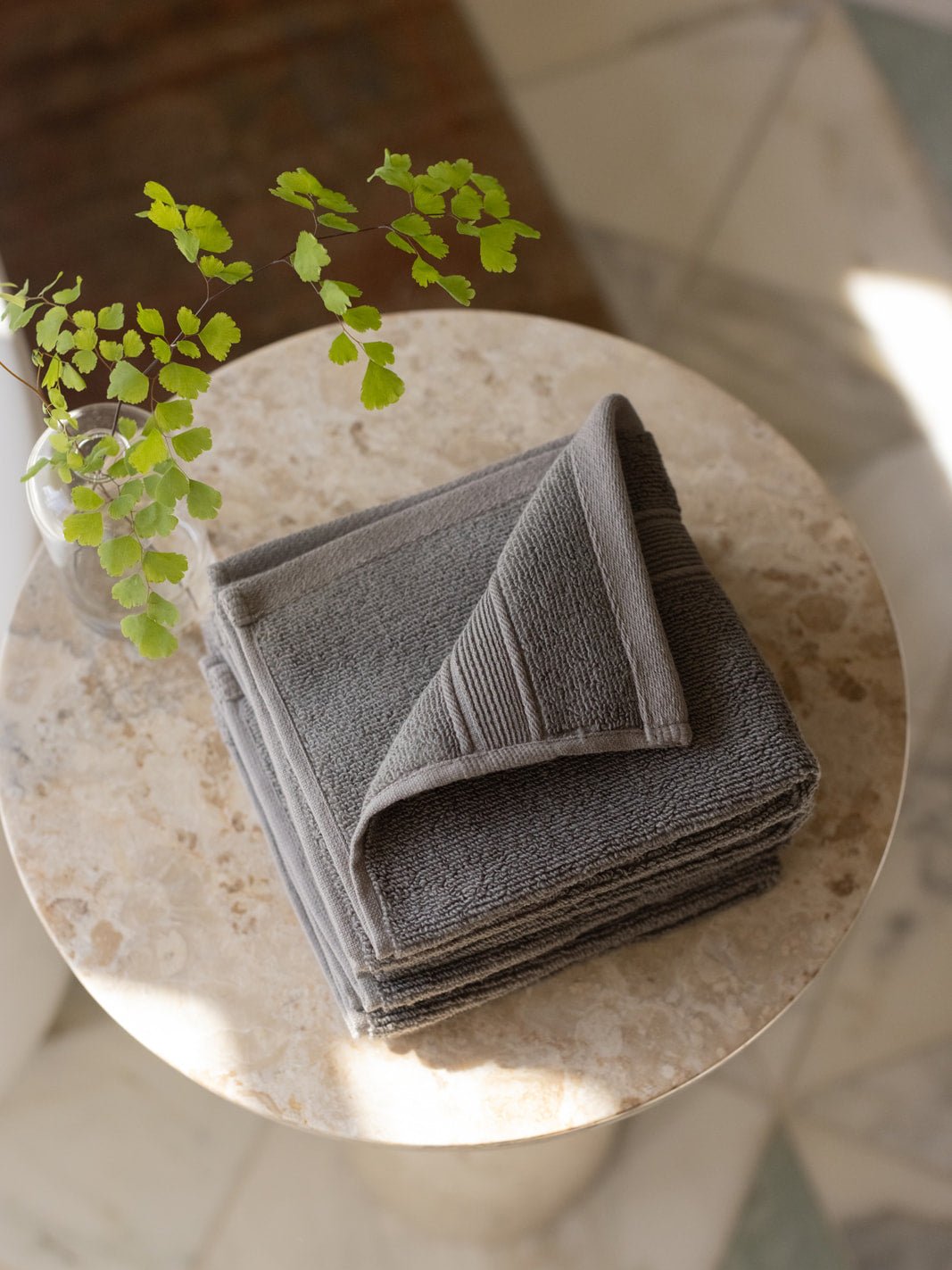 Charcoal washcloths folded on small table 