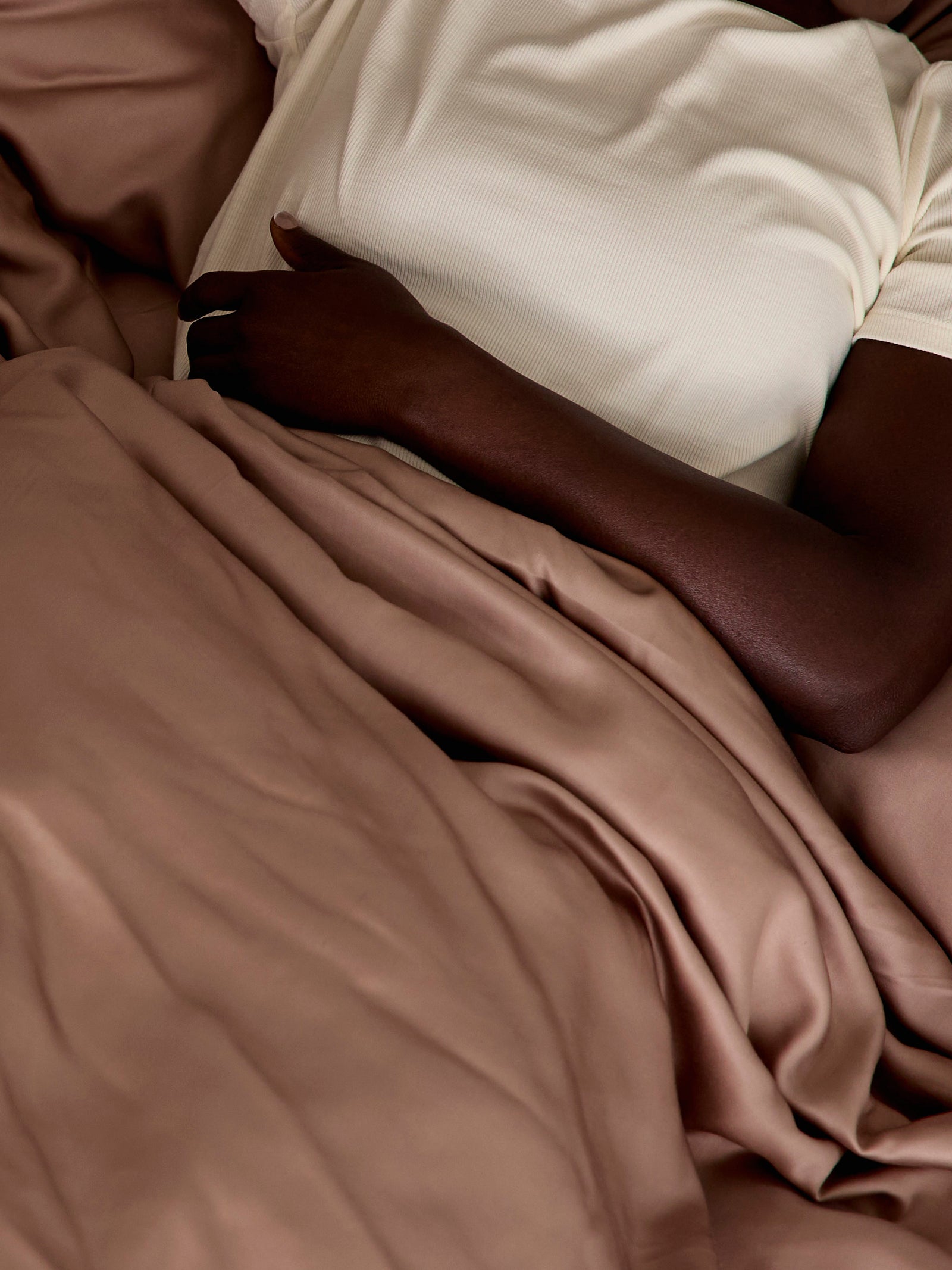 Close up of woman laying in bed with clay sheets 