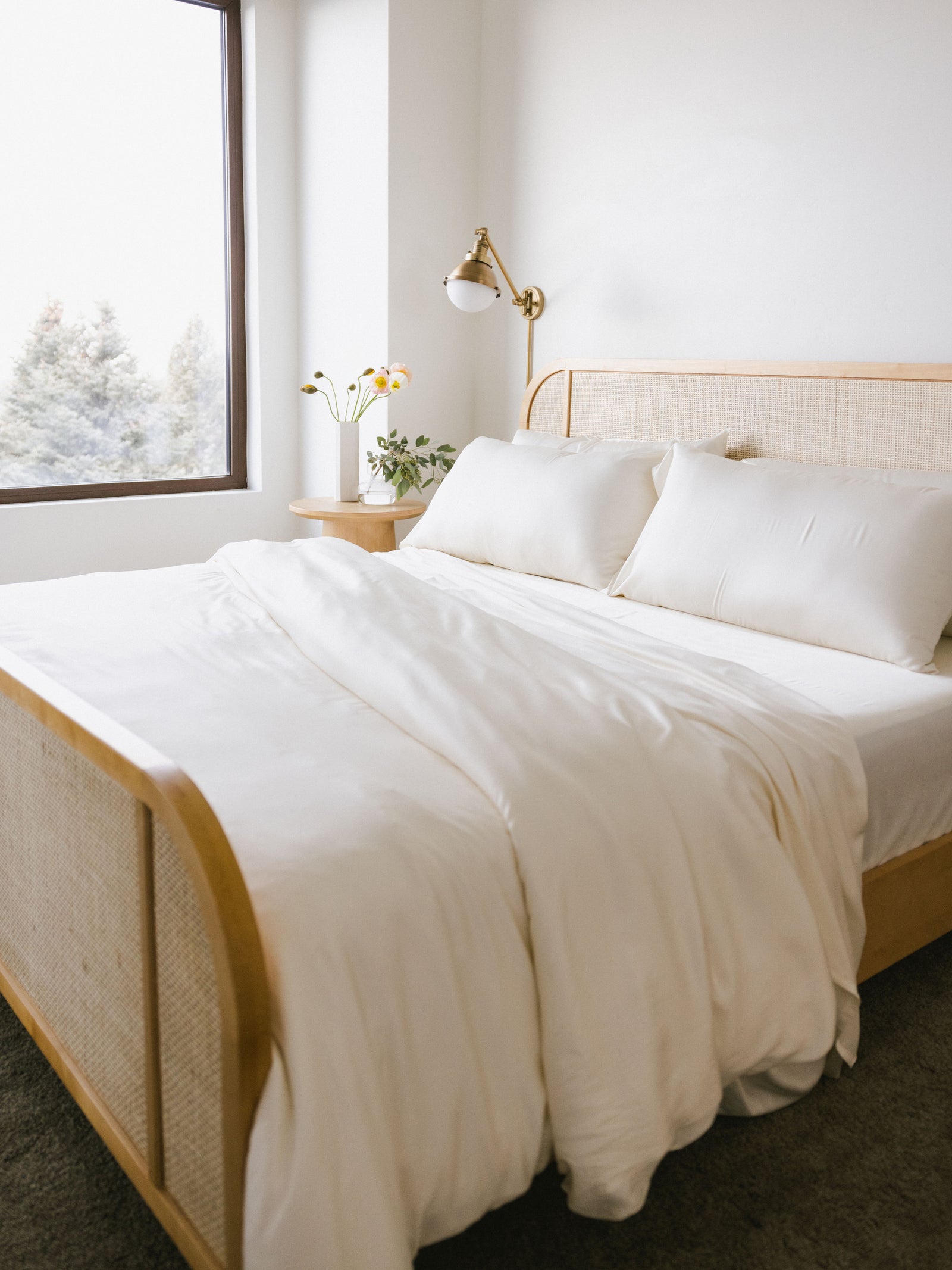 Bed with creme bedding in a clean white room 