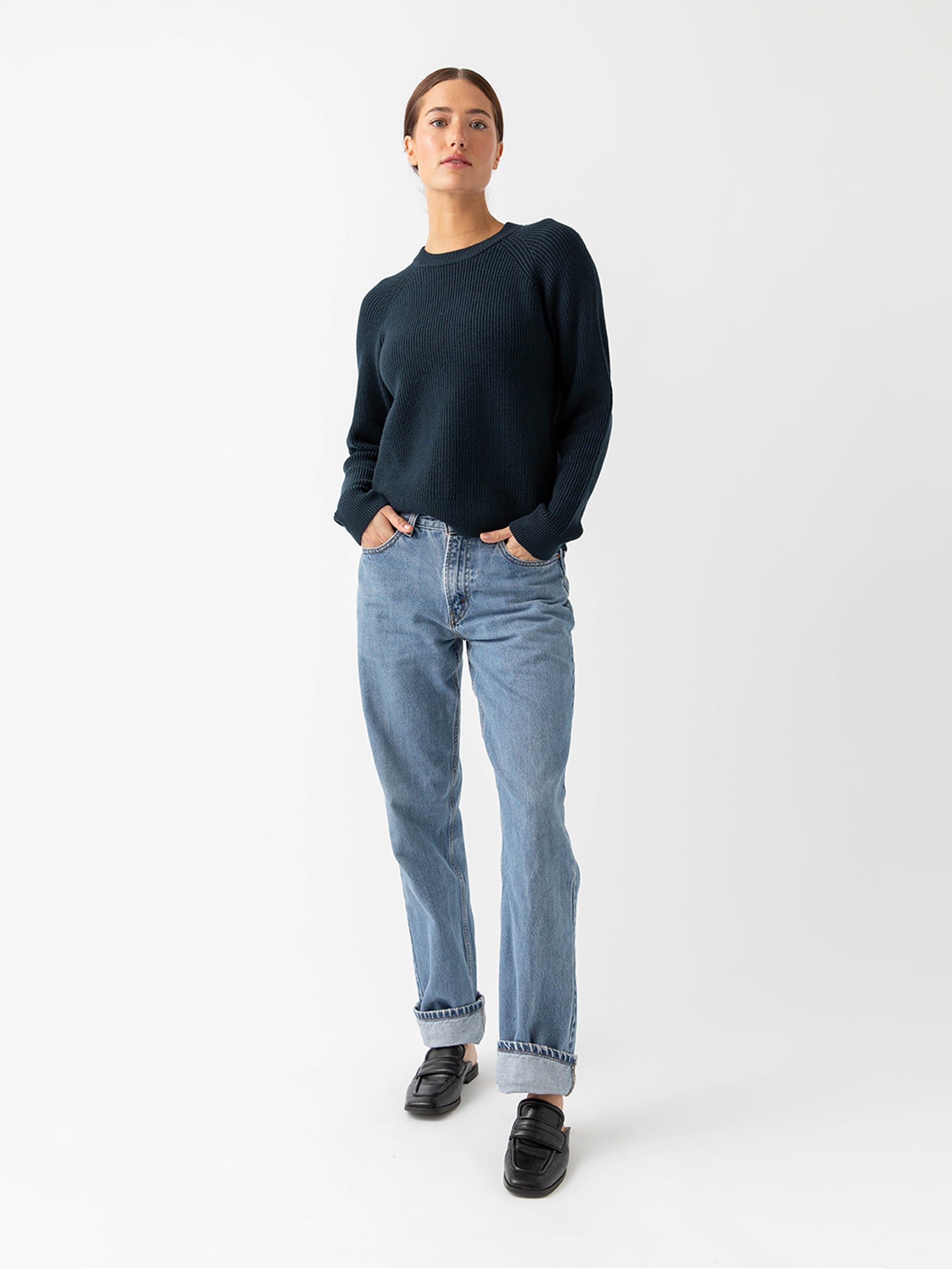 Woman wearing eclipse classic crewneck and jeans with white background