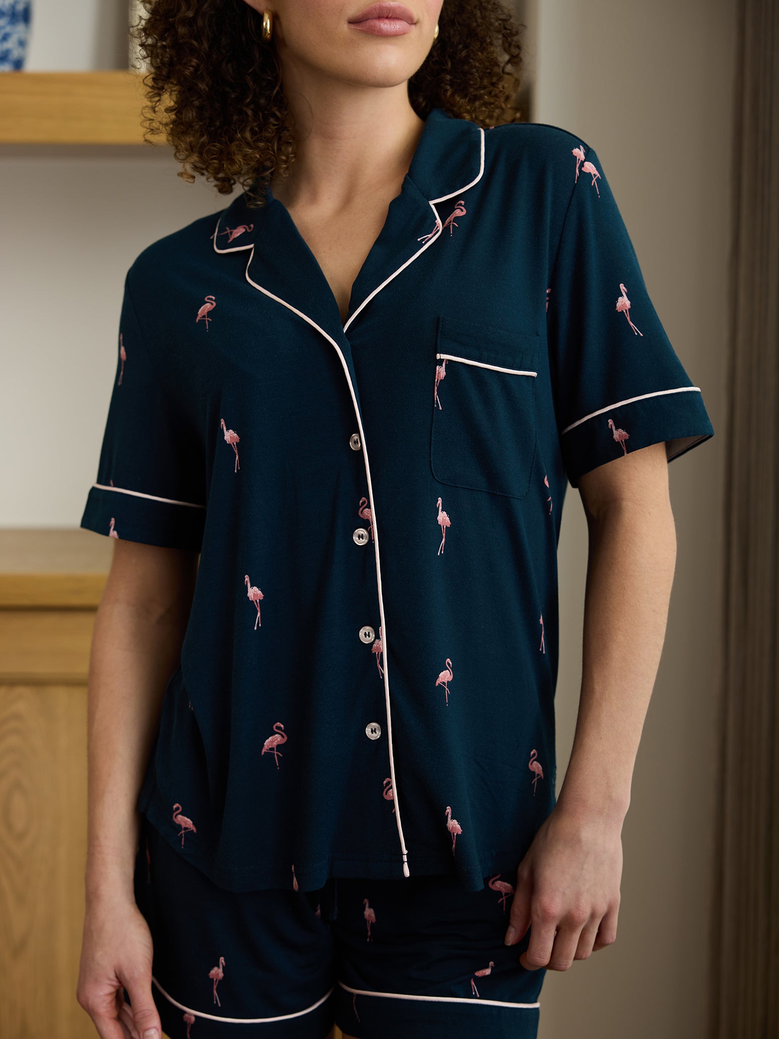 Close up of flamingo print short sleeve pajamas on woman in living room 