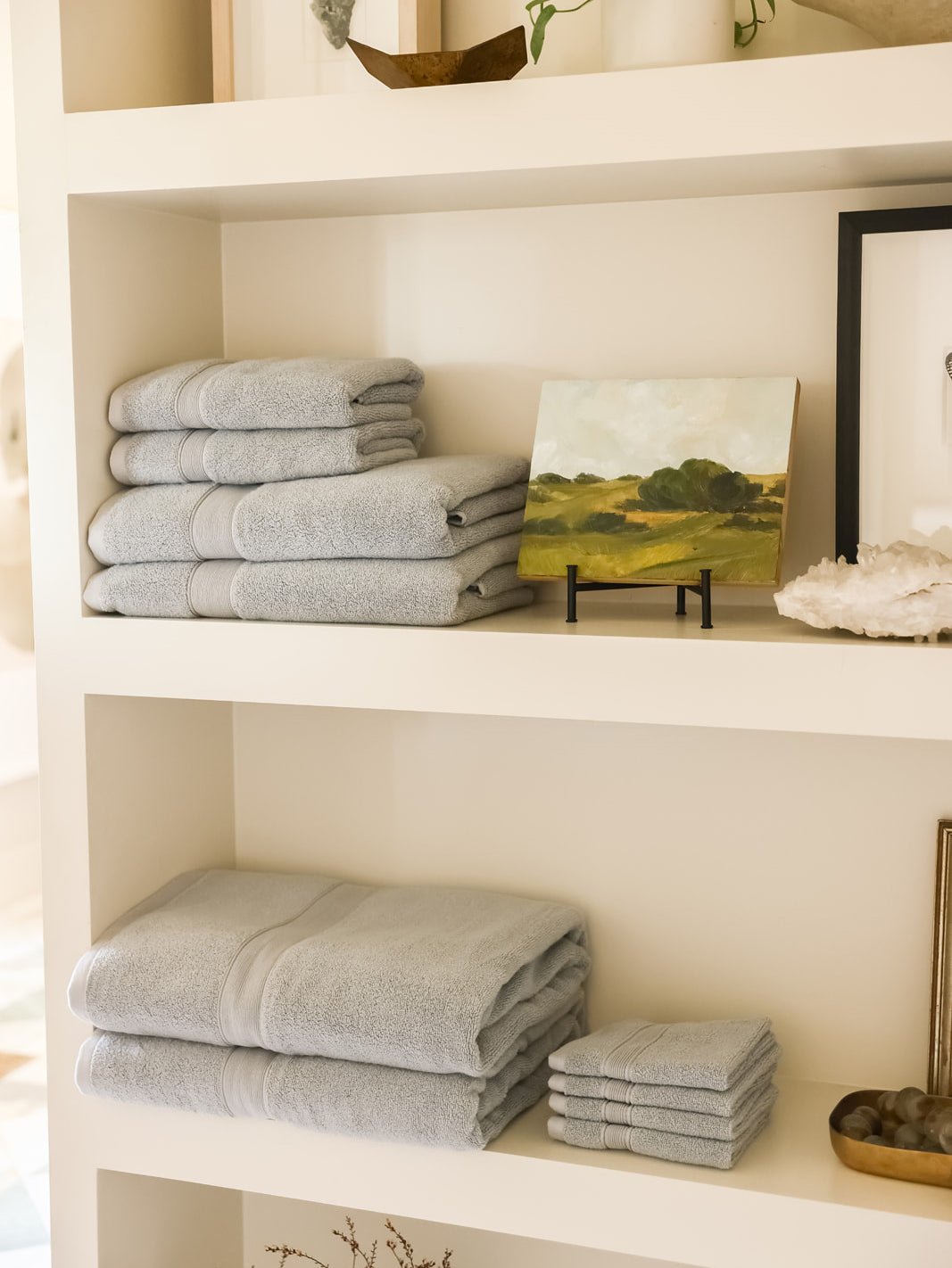 Collection of harbor mist luxe towels on shelves 