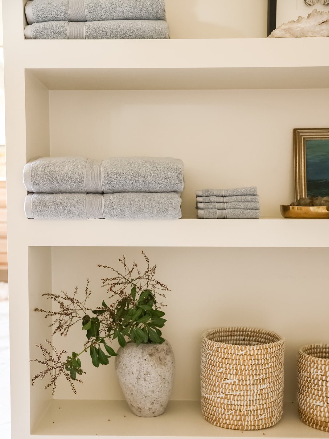 Harbor mist luxe bath towels and washcloths folded on shelves 