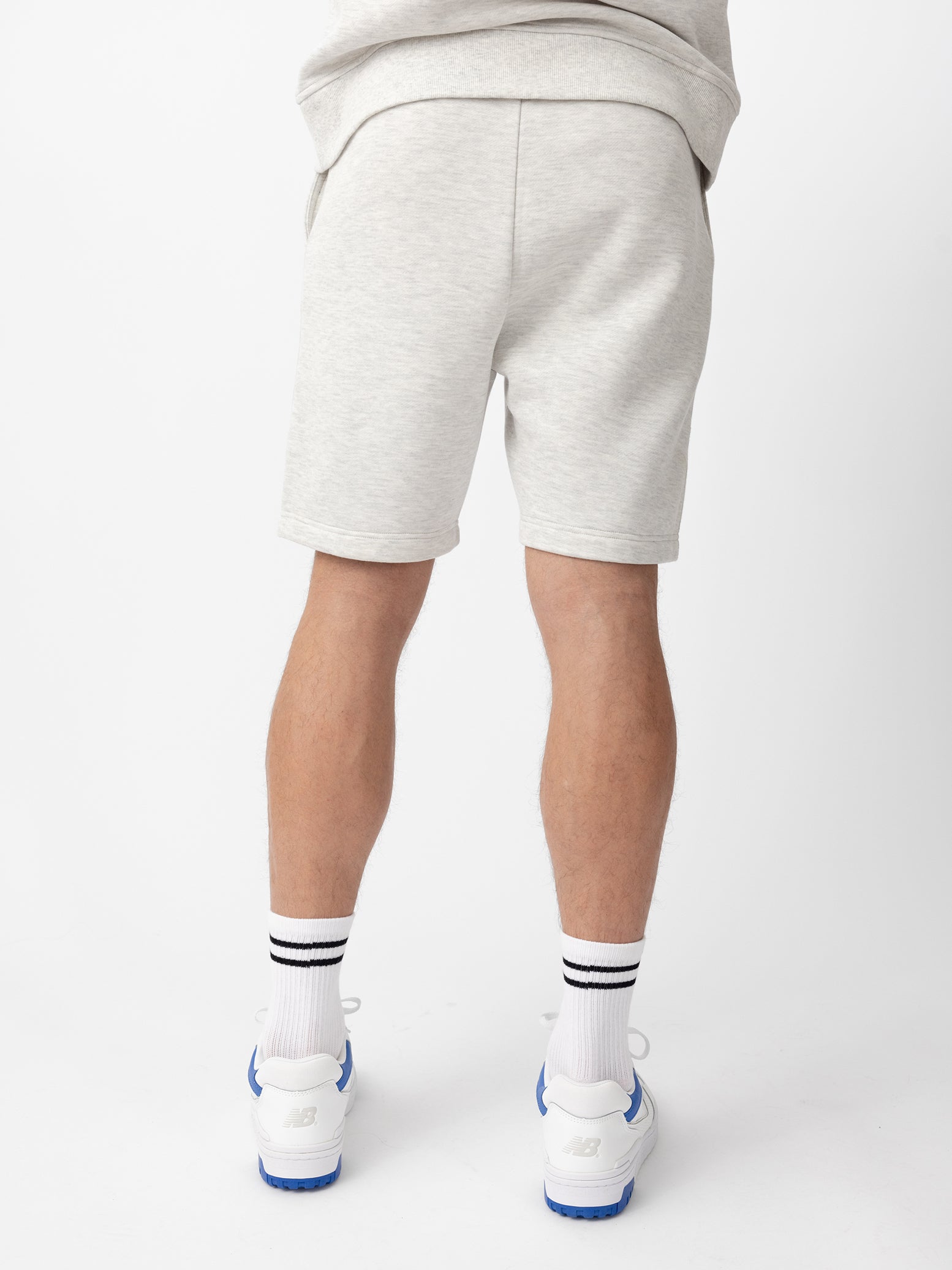 Back of man wearing heather grey cityscape shorts with white background