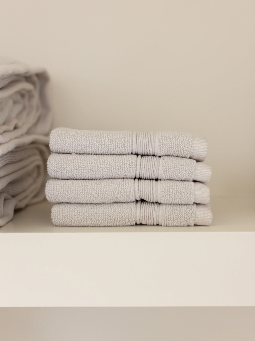 Light grey washcloths folded on shelf 