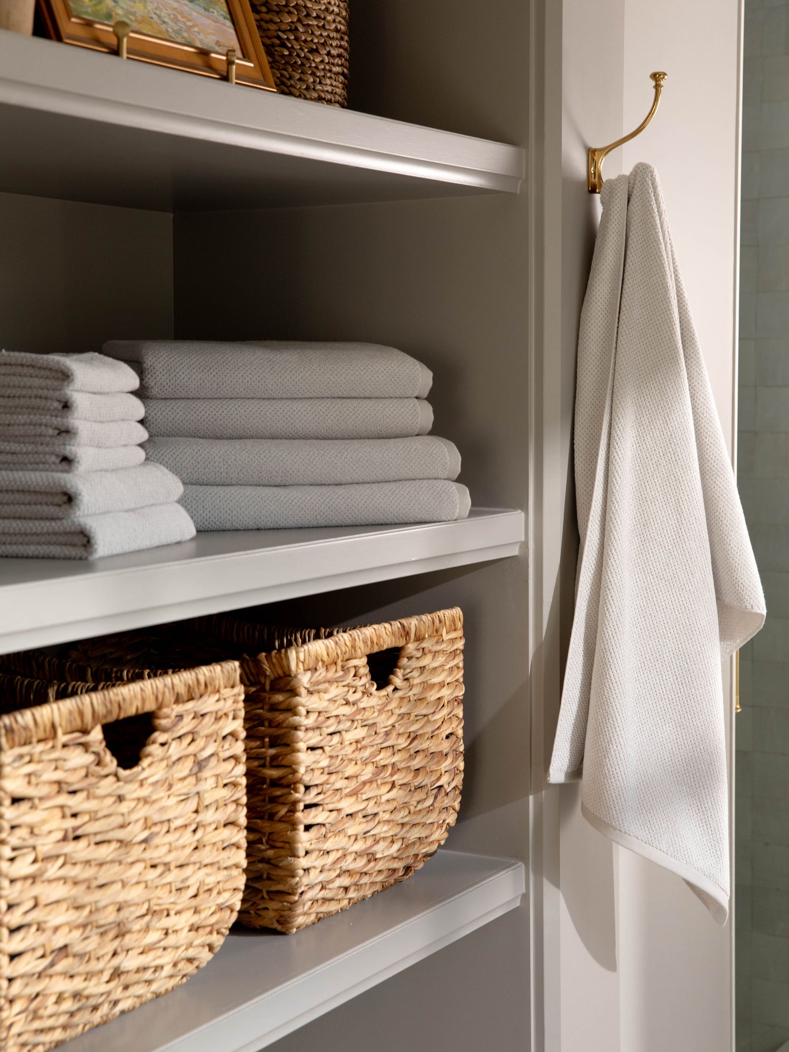 Complete Nantucket Bath Bundle in the color Heathered Light Grey. Photo of Complete Nantucket Bath Bundle taken as the towels rest on a shelf in a bathroom.
