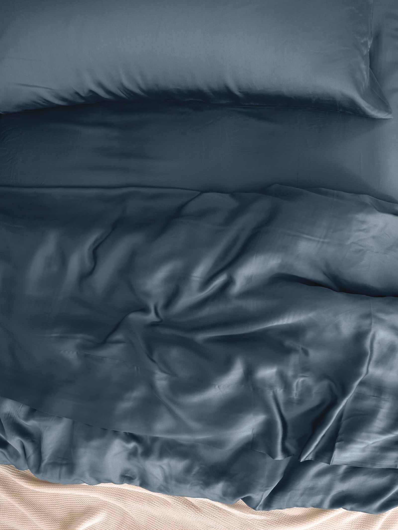 Close up of pacific blue bedding on an unmade bed