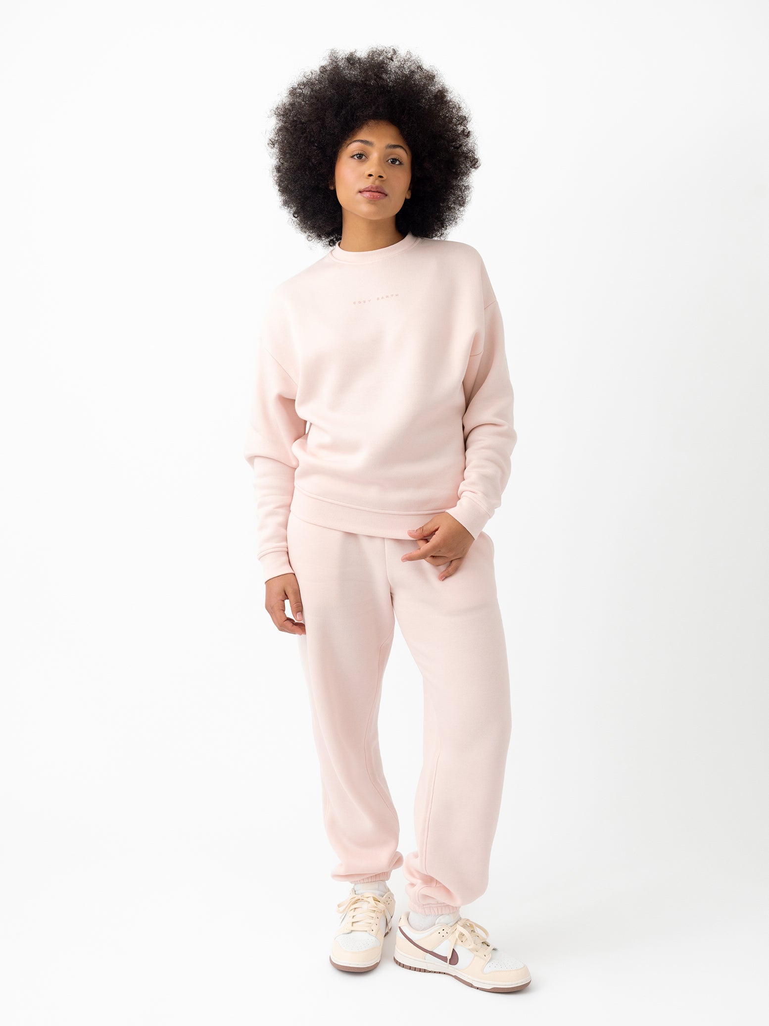 Peony CityScape Joggers. The Joggers are being worn by a female model. The photo is taken with the models hand by the pocket of the joggers. The back ground is a crisp white background. 