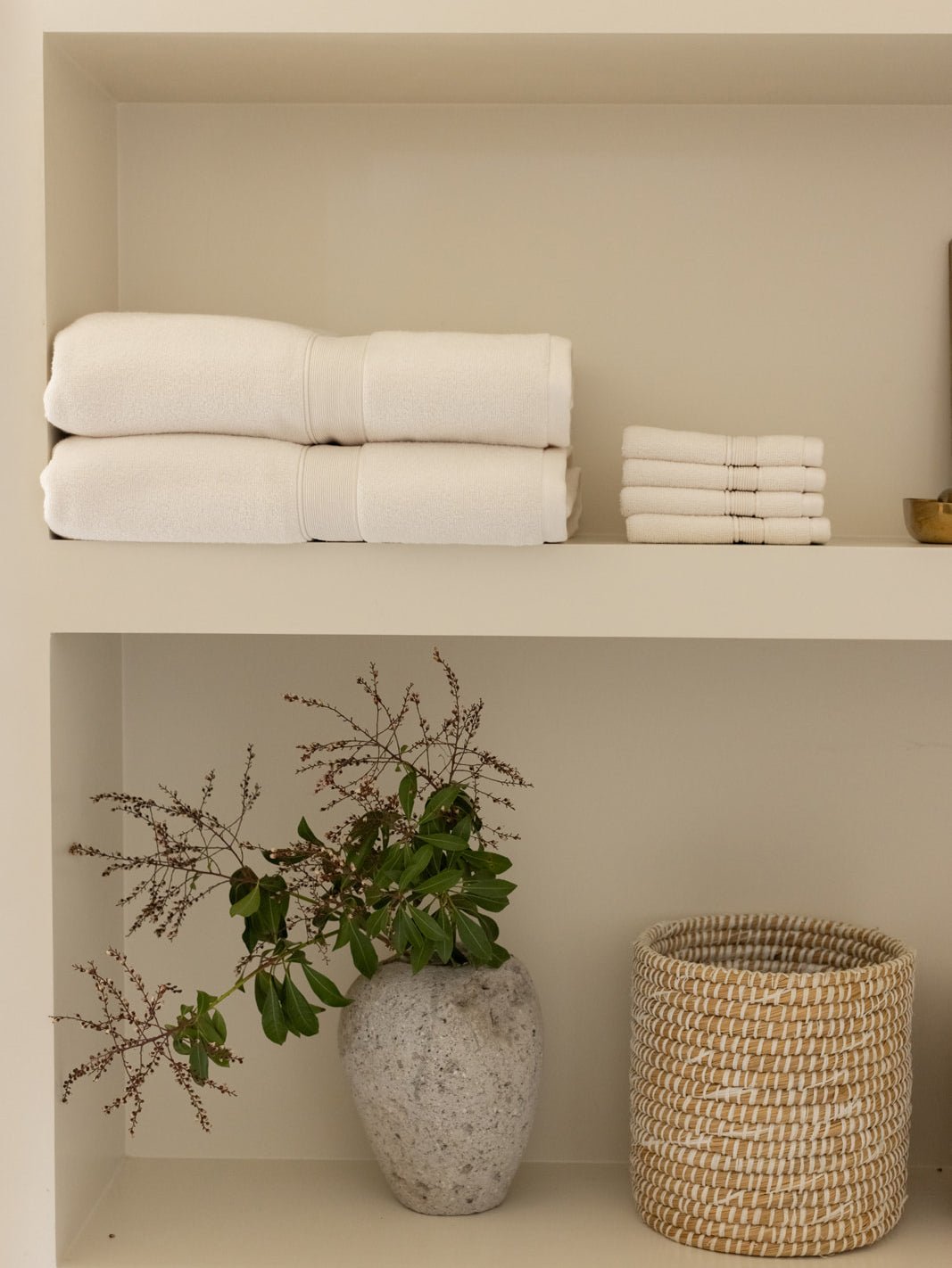 Seashell luxe bath sheets and washcloths on shelf 