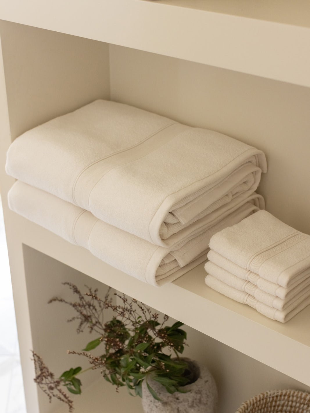 Seashell luxe bath towels and washcloths folded on shelf 
