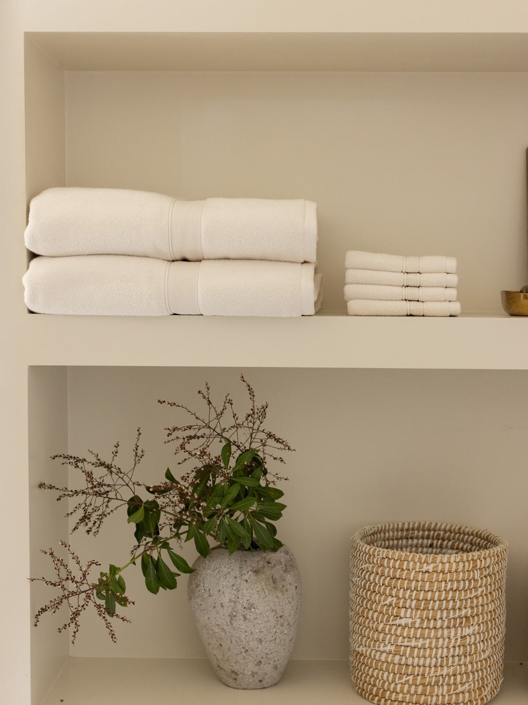 Seashell washcloths and towels folded on shelf 