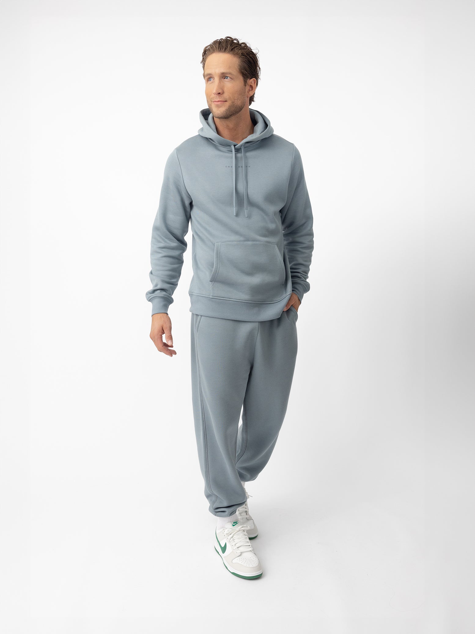 Man in smokey blue cityscape hoodie set with white background