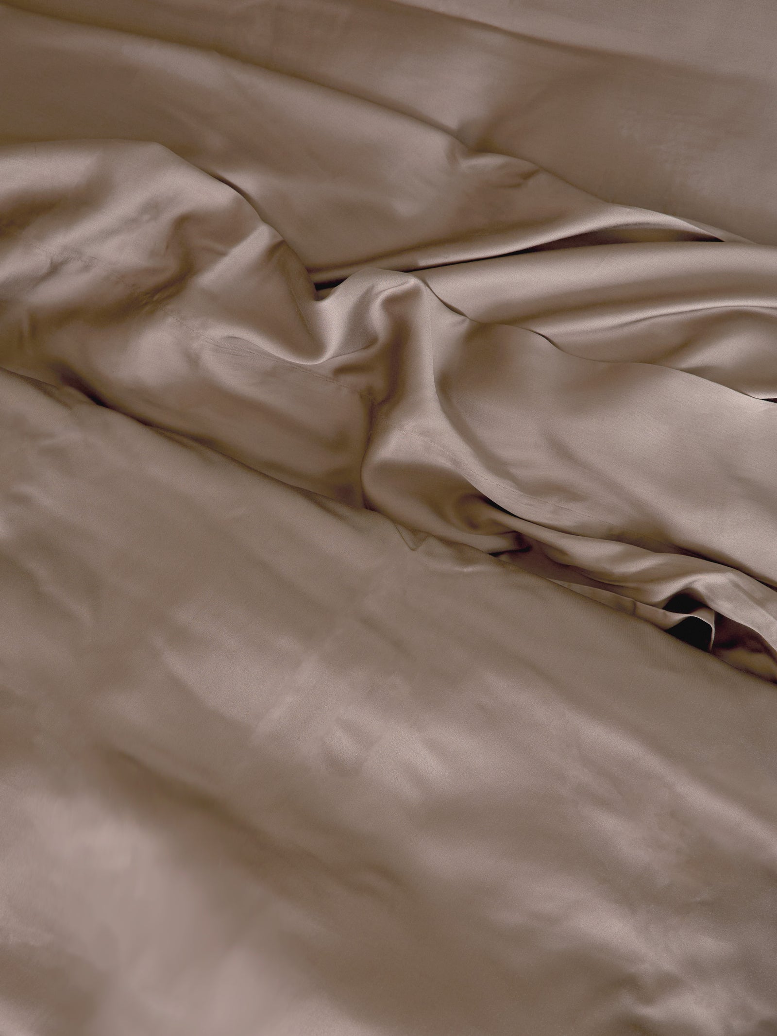Close up of walnut bedding in an unmade bed 