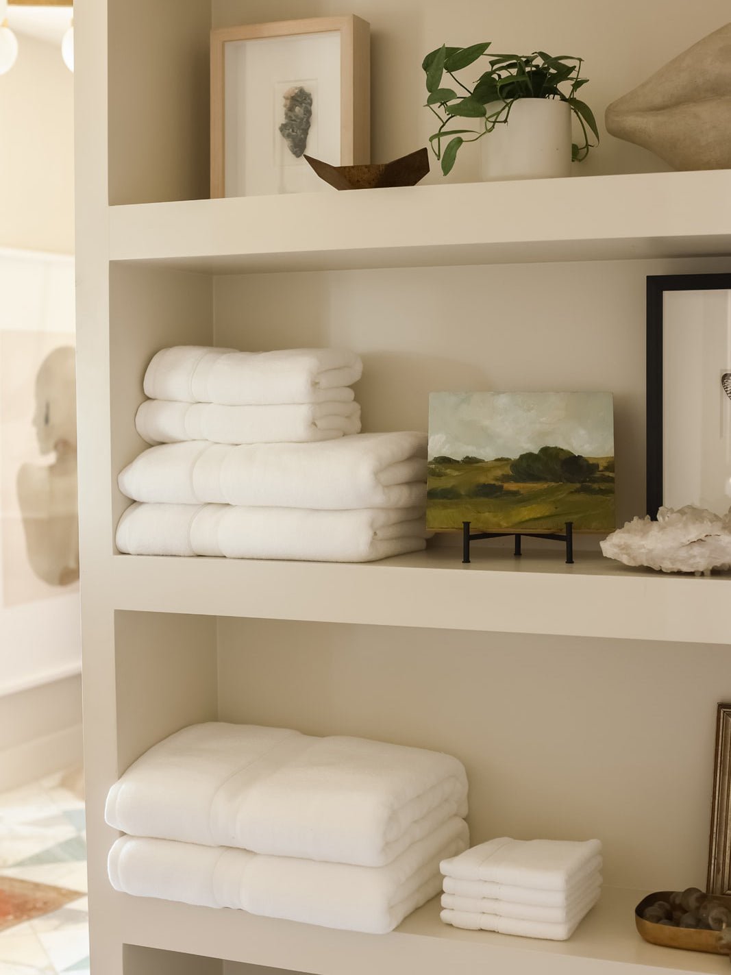 Collection of white luxe towels folded on shelves 