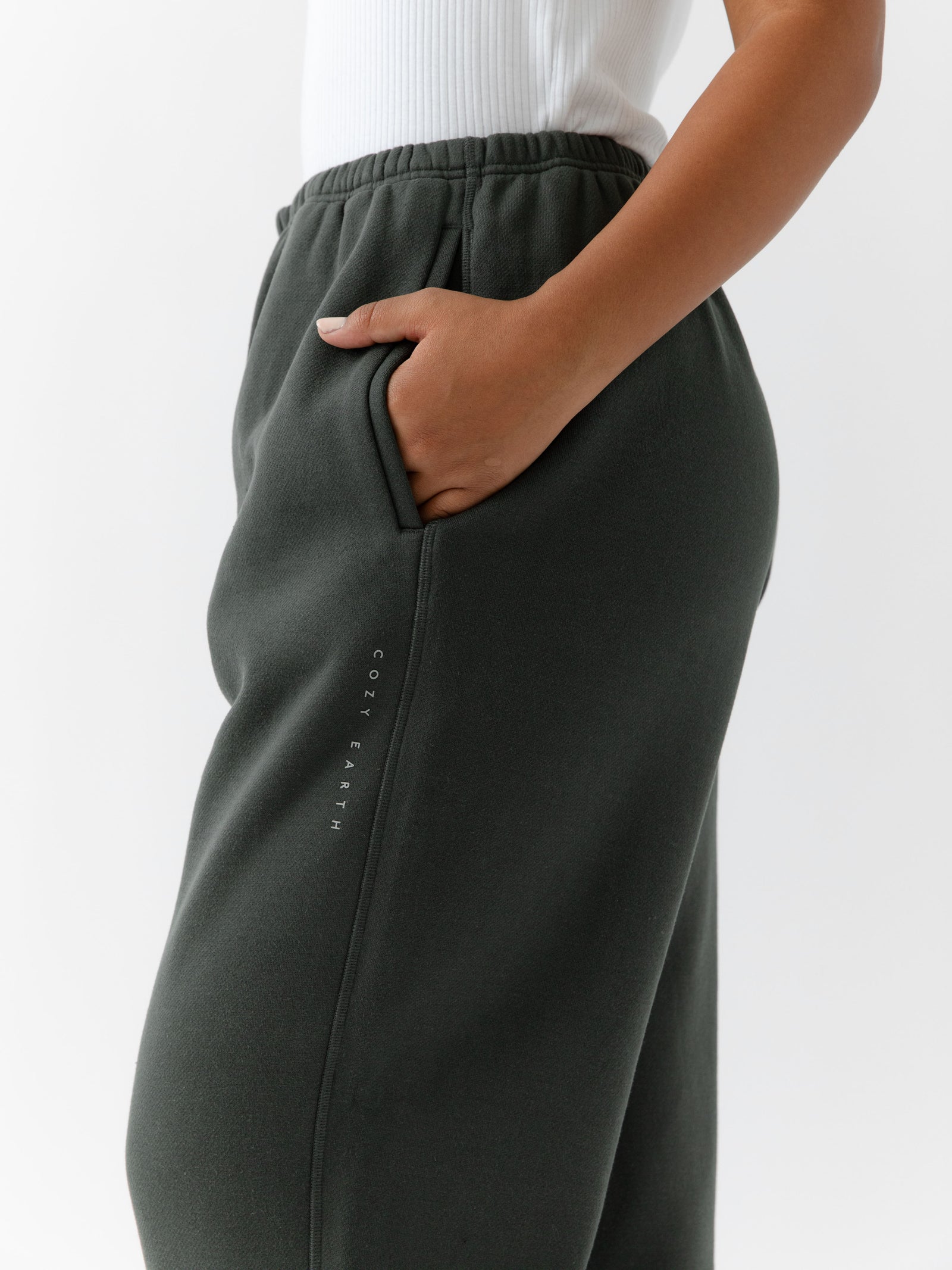 Storm CityScape Joggers. The Joggers are being worn by a female model. The photo is taken from the waist down with the models hand in the pocket of the joggers. The back ground is white.
