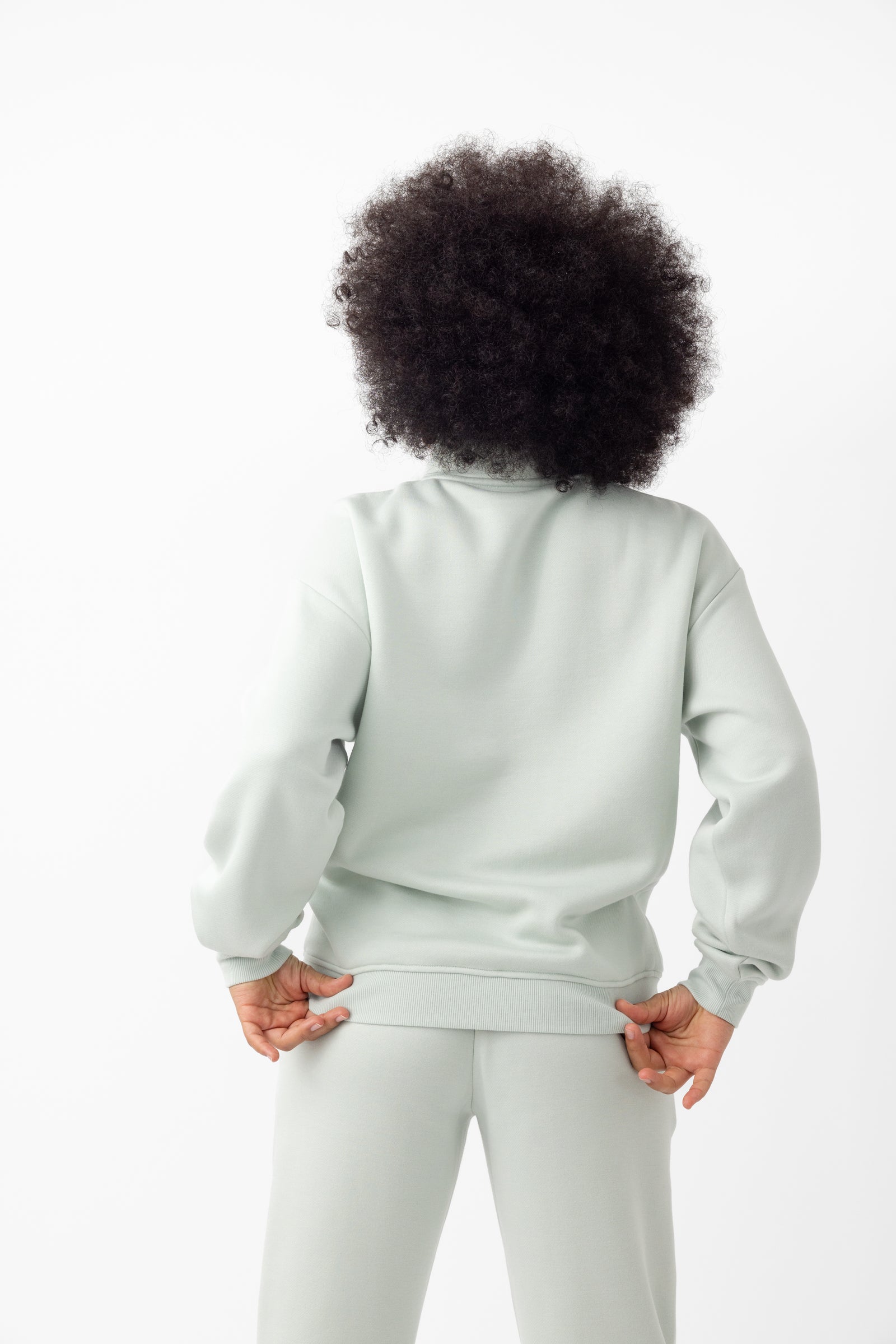 Arctic CityScape Quarter Zip. The quarter zip is being worn by a female model. The model is wearing accompanying CityScape clothing to complete the look of the quarter zip. The photo was taken with a white background.