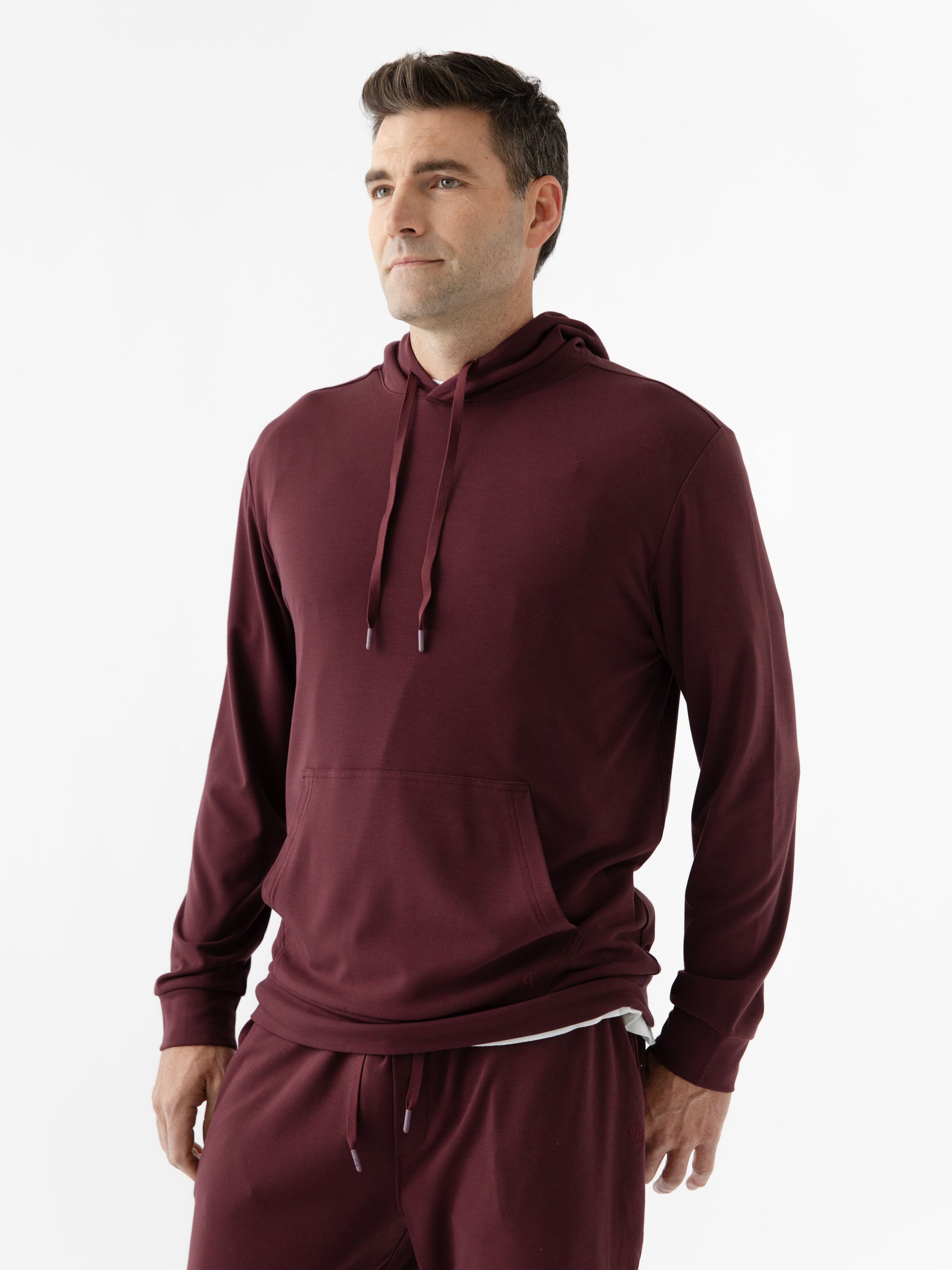 Burgundy Bamboo Hoodie worn by man standing in front of white background.