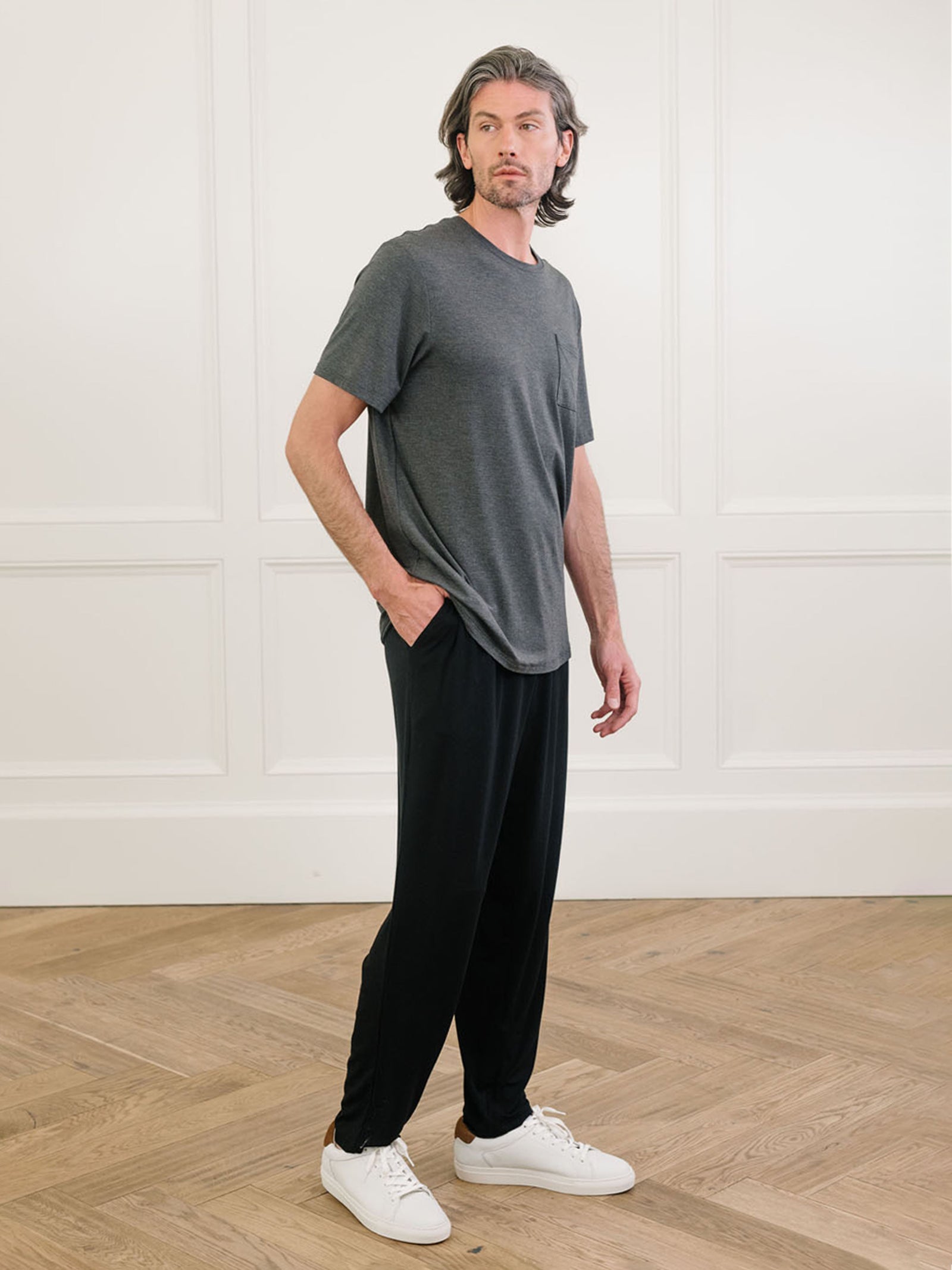 Charcoal Men's Stretch-Knit Bamboo Lounge Tee. A man is wearing the lounge tee in a well lit home.