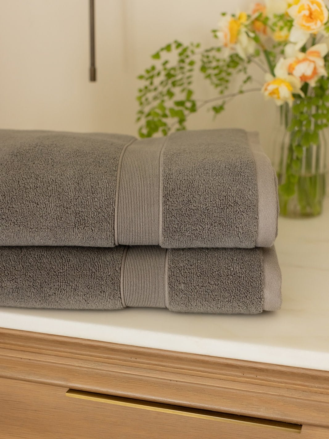 Charcoal luxe bath towels folded on bathroom counter 