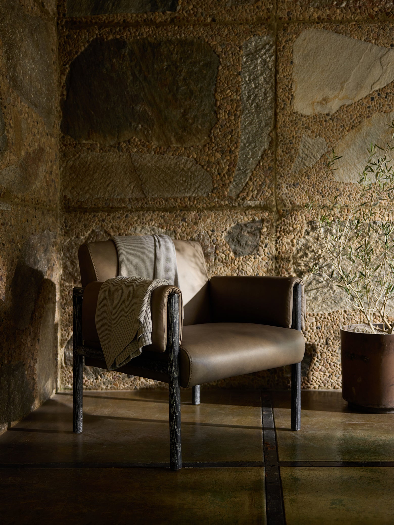 Dove Grey Classic Knit Blanket draped over a leather chair.