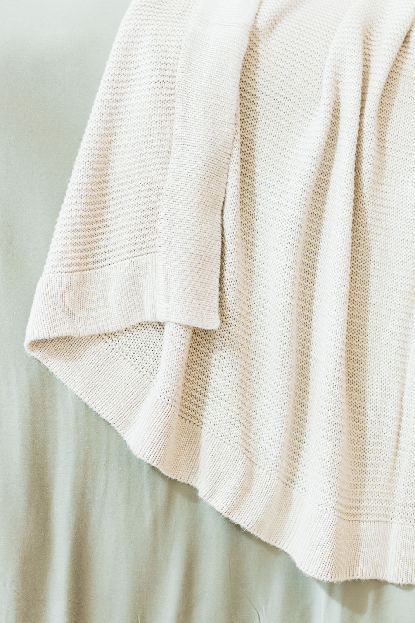 Driftwood cloud knit blanket close up draped over bed