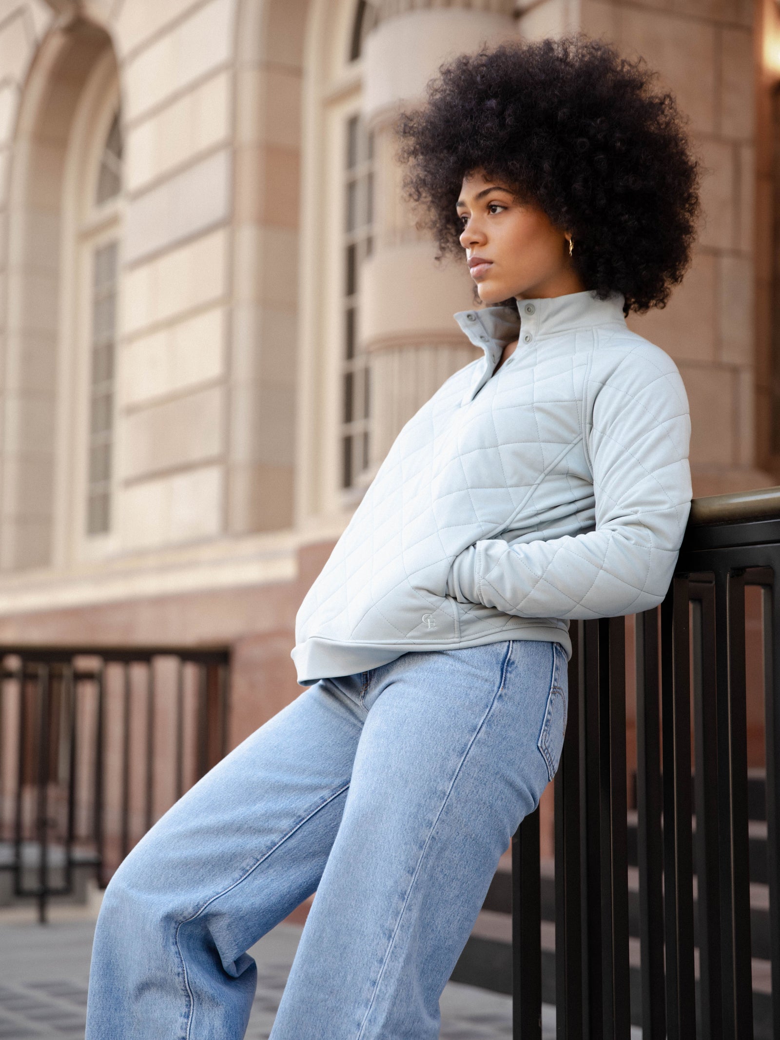 Woman wearing a white Cozy Earth Brushed Bamboo Quilted Pullover against a city background