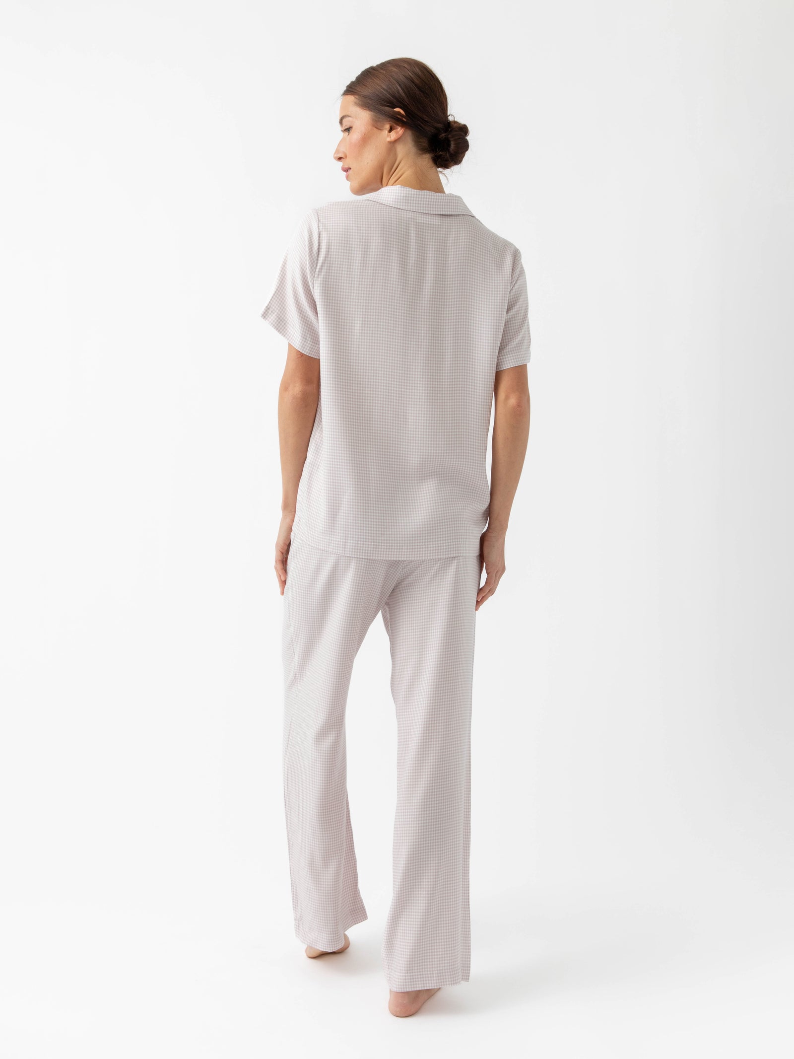 Back of woman in lavender mini gingham pajama set with white background