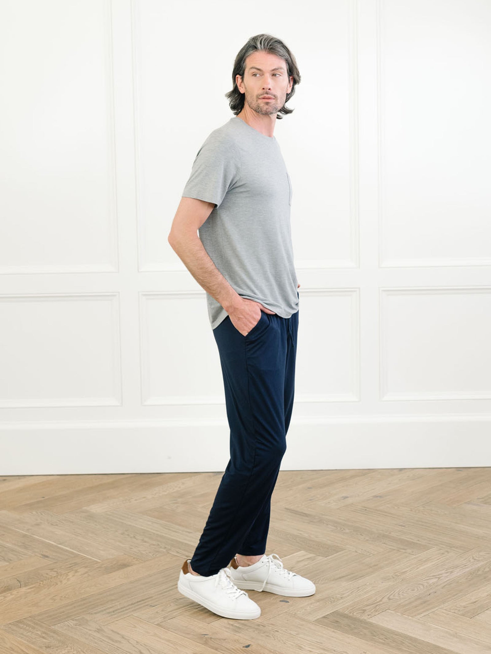 Heather grey Men's Stretch-Knit Bamboo Lounge Tee. A man is wearing the lounge tee in a well lit home.