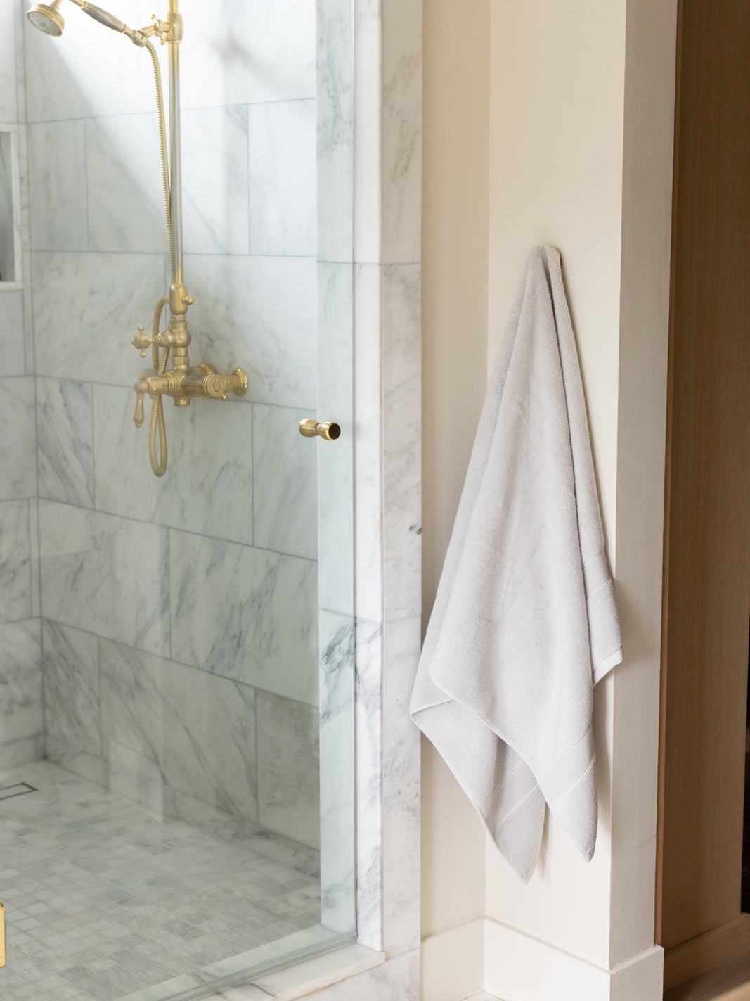Light grey luxe bath towel hanging next to shower 