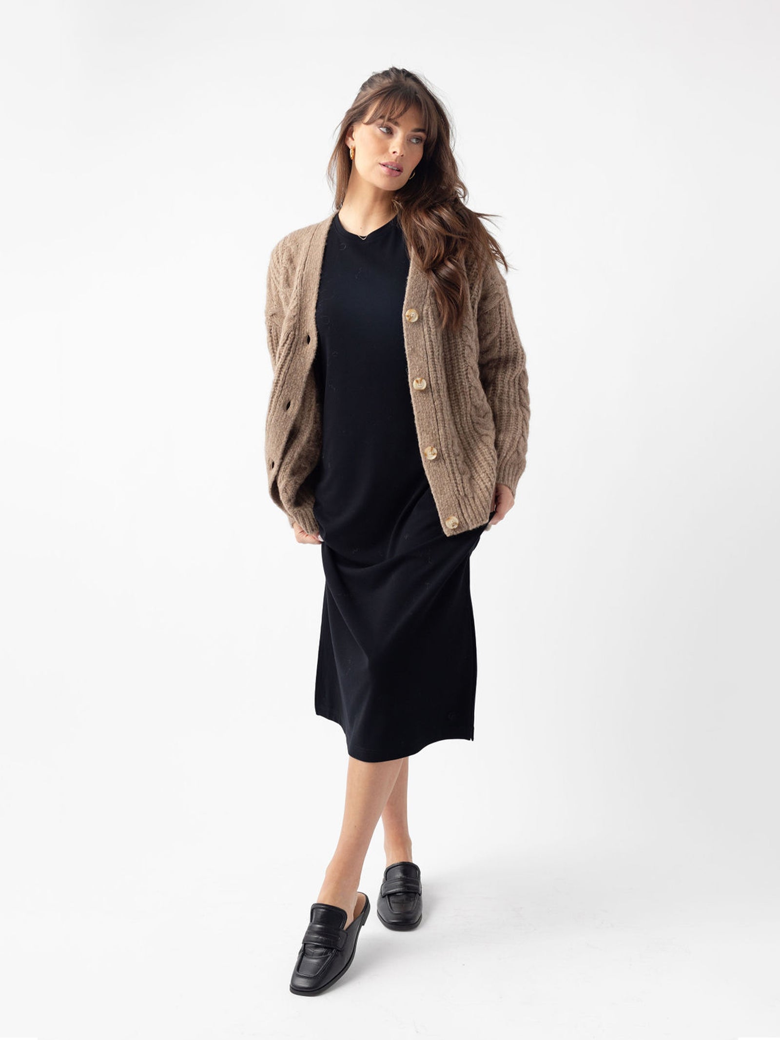 Woman in black dress and mushroom cardigan with white background