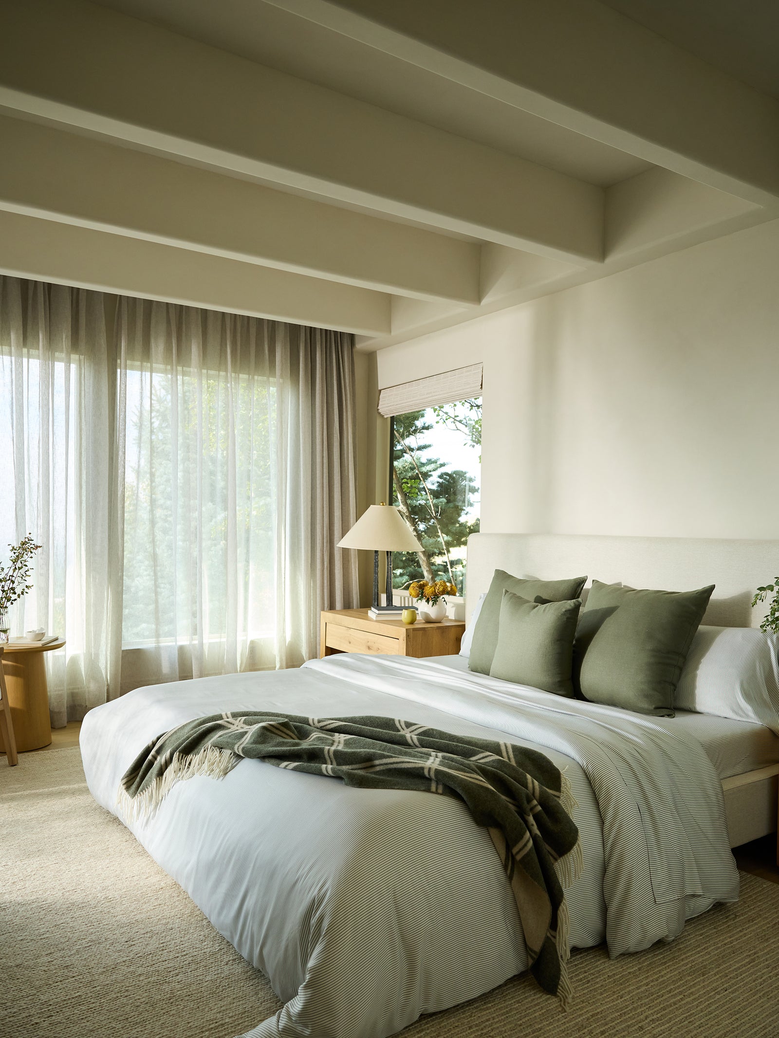 Olive cortina throw laying on the edge of a bed