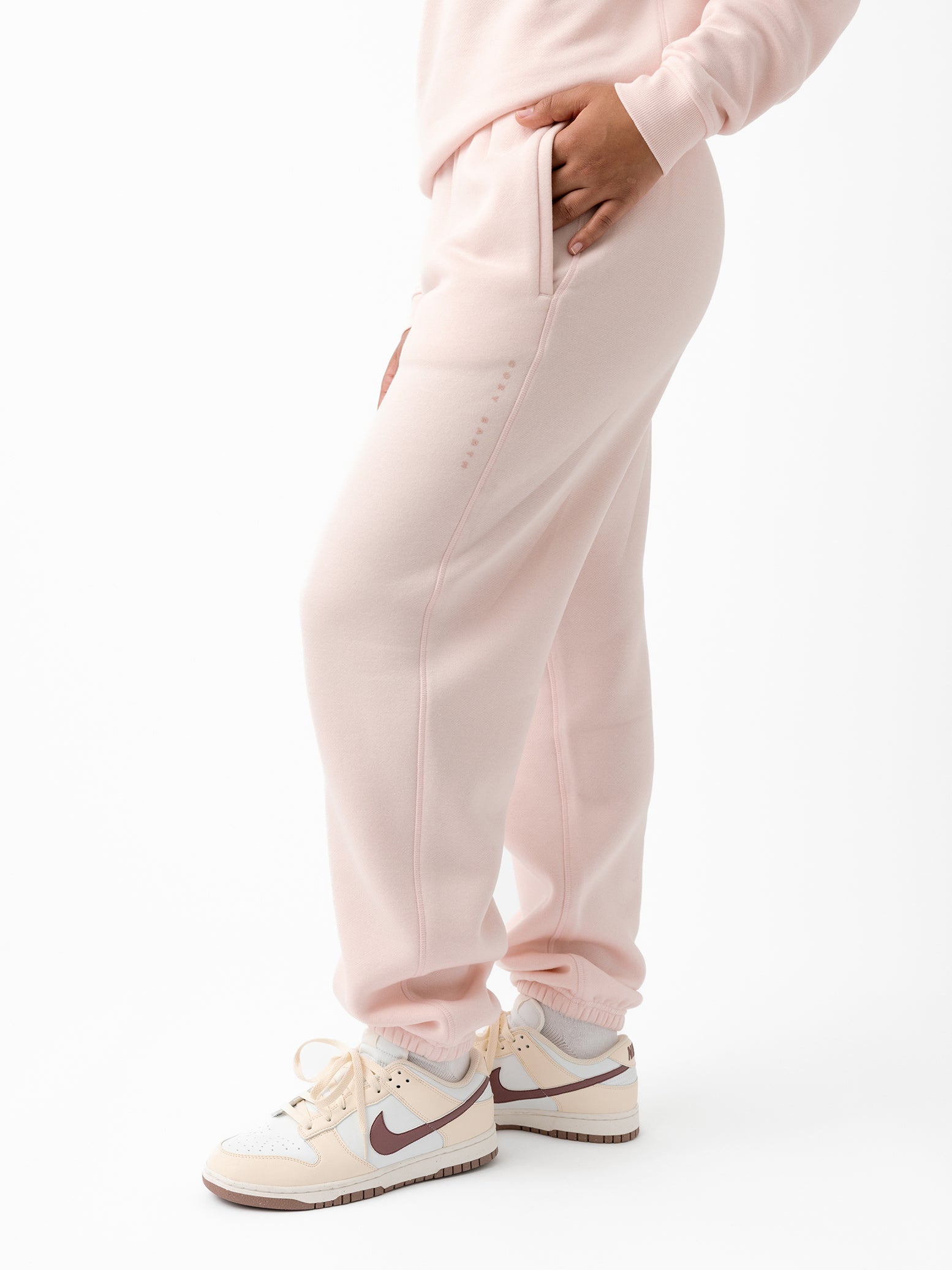 Peony CityScape Joggers. The Joggers are being worn by a female model. The photo is taken from the waist down with the models hands by the pocket of the joggers. The back ground is white. 