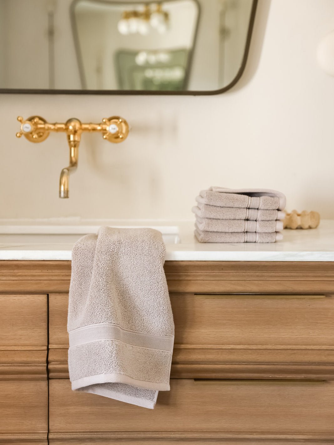 Sand hand towel and washcloths on bathroom sink 