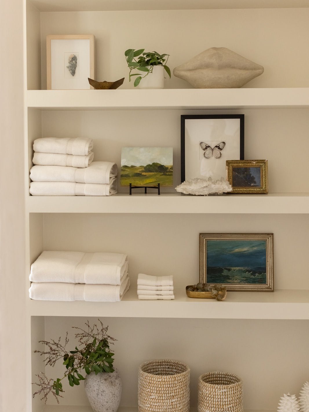 Collection of seashell towels folded on shelves 