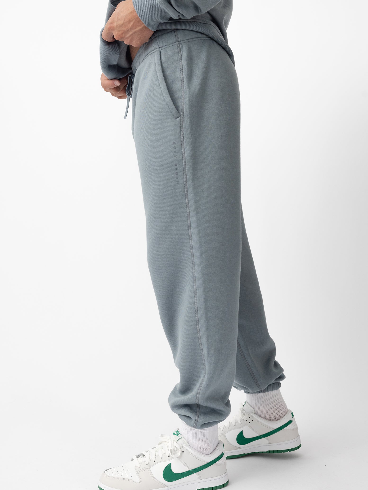 Man wearing smokey blue cityscape sweats with white background