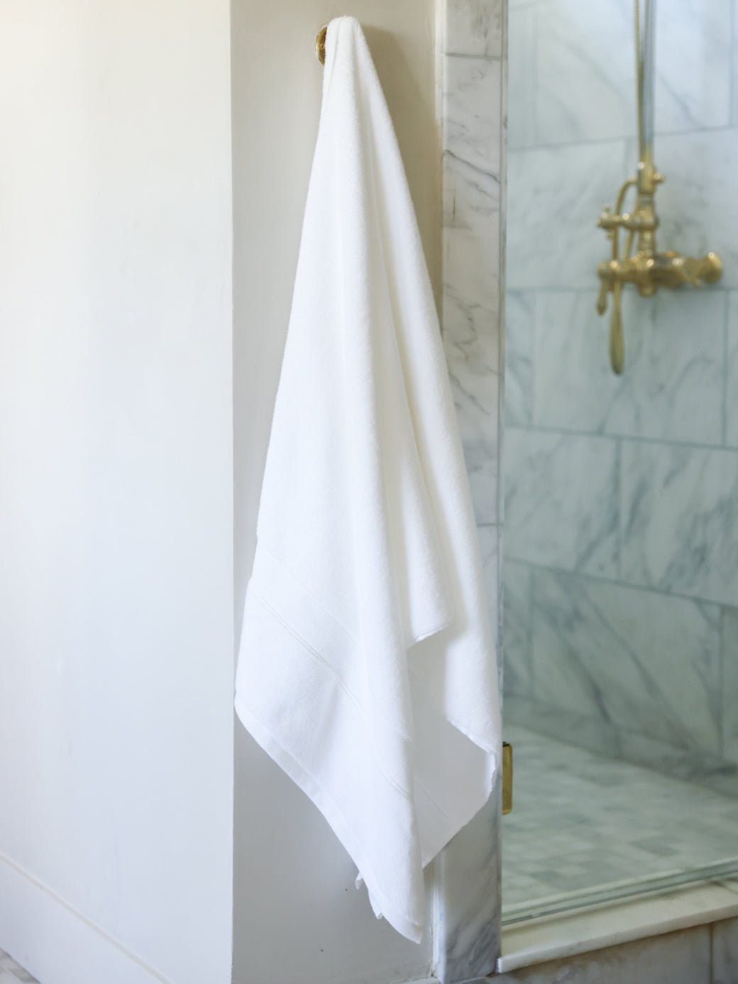 White luxe bath sheet hanging next to the shower 