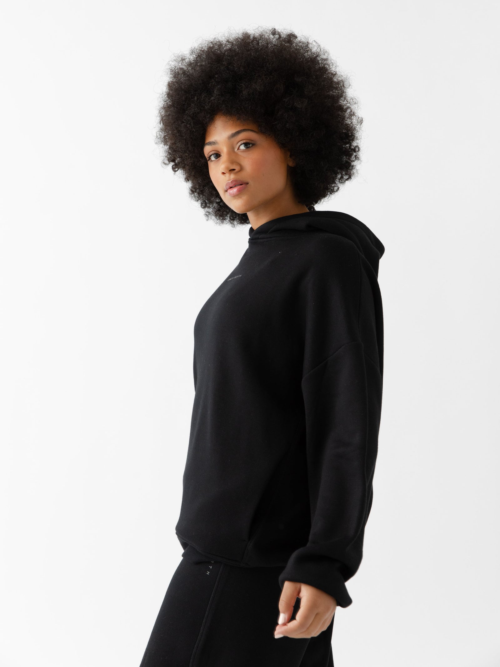 Woman wearing black cityscape hoodie with white background 
