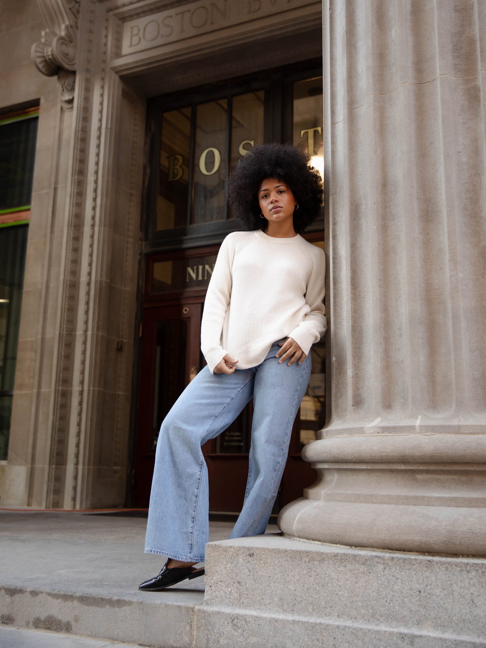 Woman wearing alabaster classic crewneck and jeans outside of building