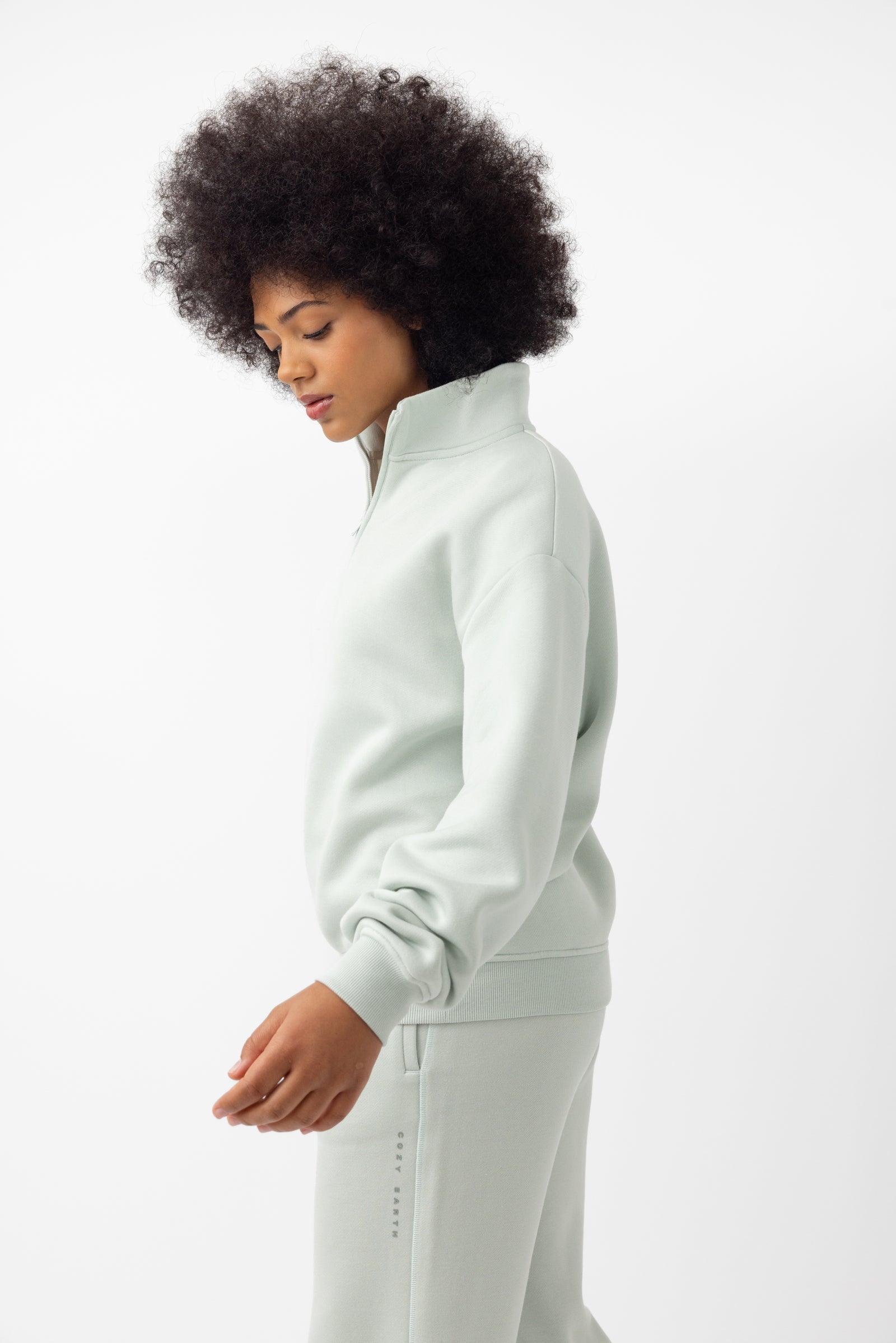 Arctic CityScape Quarter Zip. The quarter zip is being worn by a female model. The model is wearing accompanying CityScape clothing to complete the look of the quarter zip. The photo was taken with a white background. 