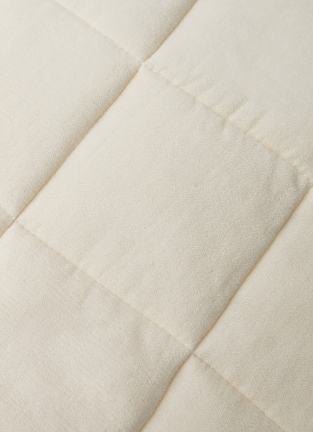 Close up of Buttermilk Aire Bamboo Box Quilt Euro Sham. The sham is resting on a bed in a bedroom