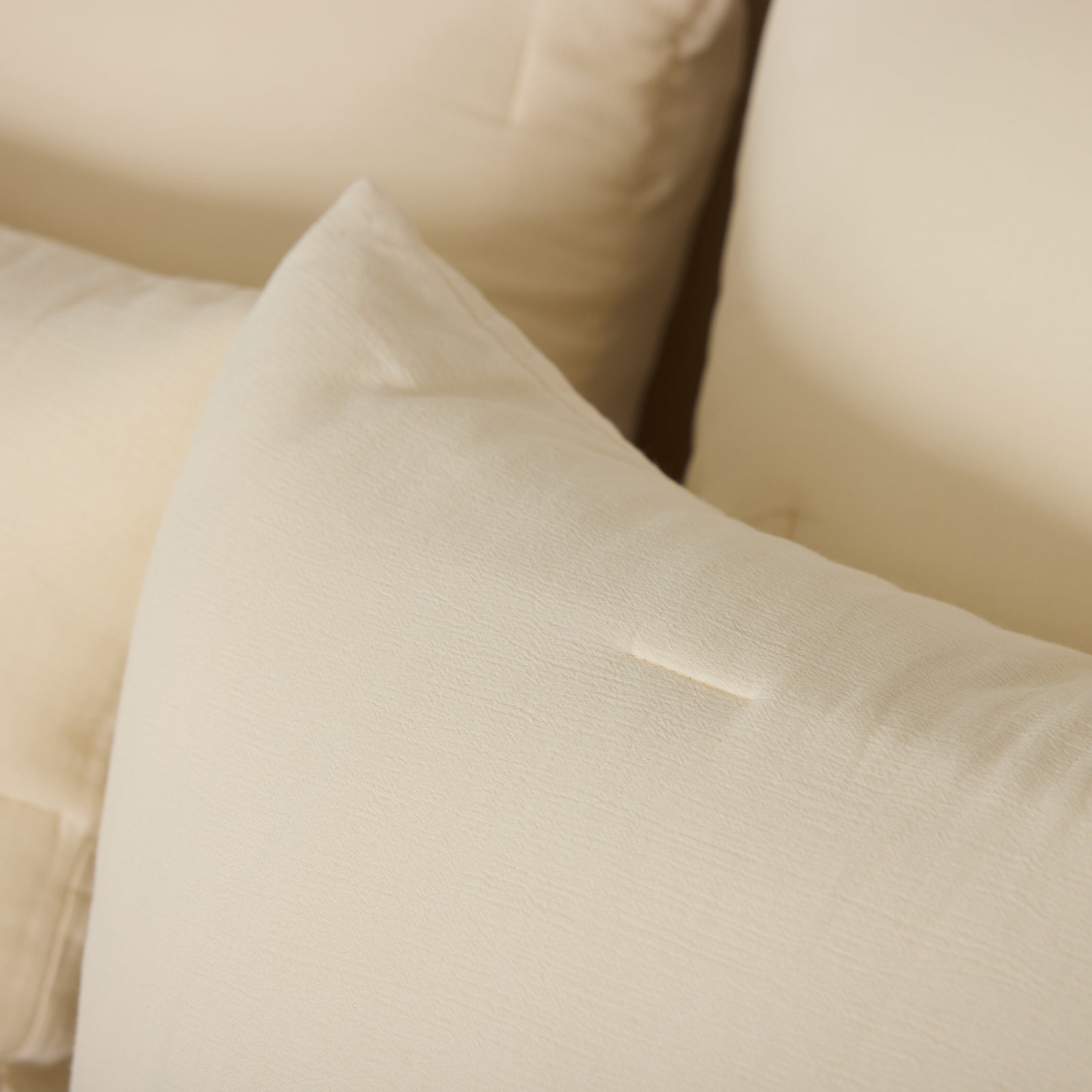 Close up of Buttermilk Aire Bamboo Puckered Shams. The shams are resting on a bed in a bedroom