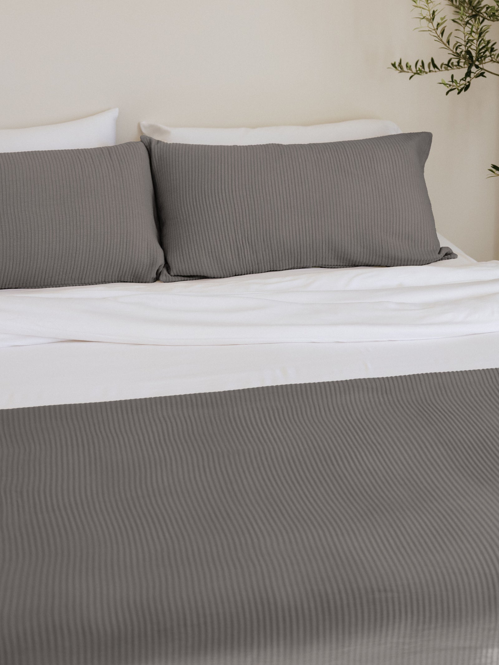 Charcoal shams and coverlet on a bed 