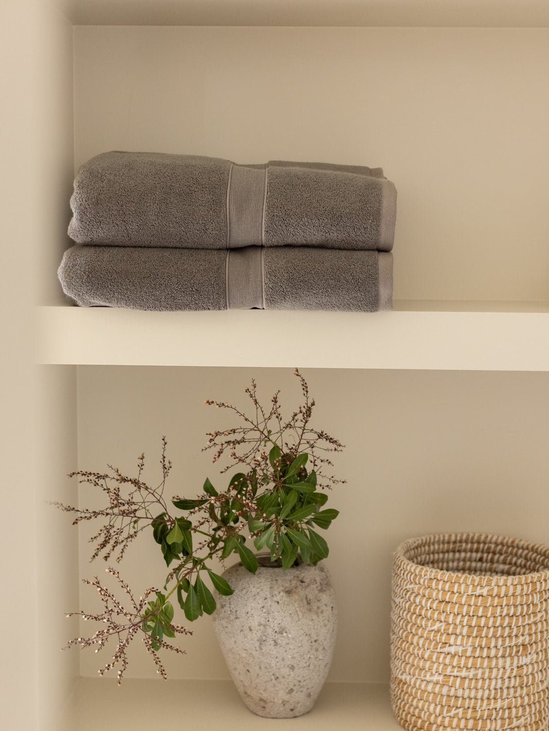 Luxe bath towels on shelf above plant 