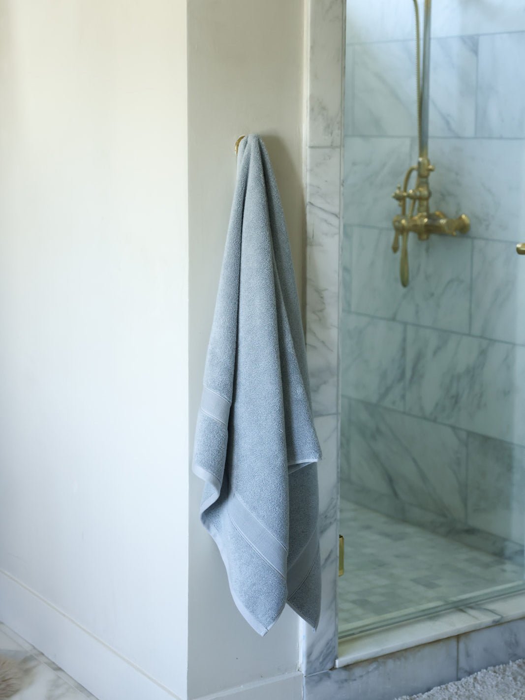 Harbor mist luxe bath towel hanging next to shower 